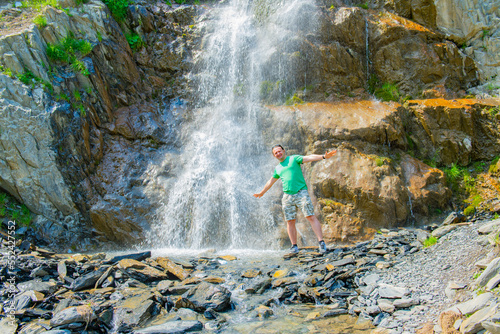 one man in a green T-shirt at a waterfall