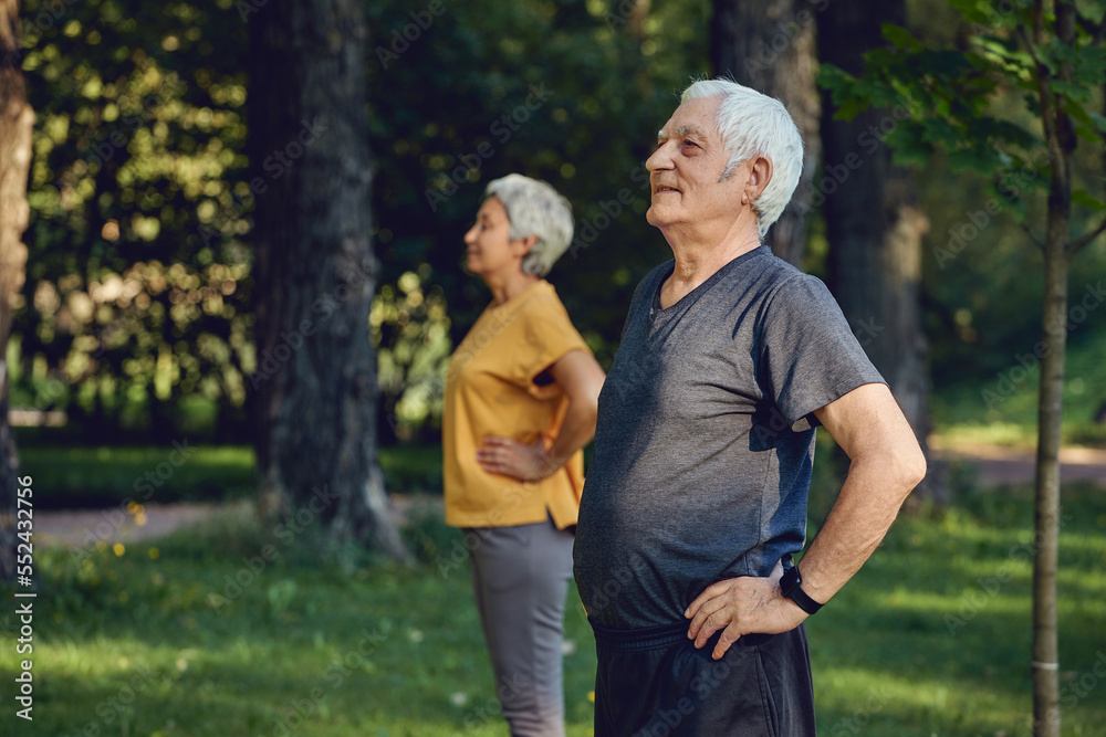 Senior spouses wear sportswear doing exercises outdoor