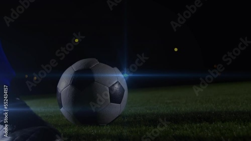 Animation of blue light spot of low section of male soccer player kicking the ball photo