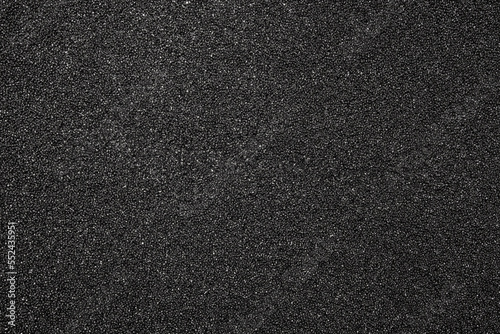 The texture of dense black foam rubber.The background of the foam is black.The substrate is made of black foam rubber. photo