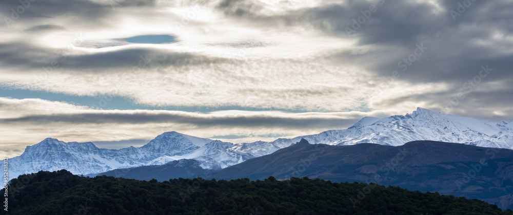 Beautiful lenticular clouds over the snowy peaks of Sierra Nevada (Granada, Spain)