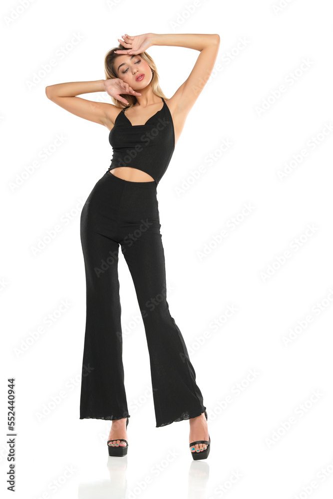 a young woman in black wide trousers and bra posing on a white background a young woman in black wide trousers and bra posing on a white background