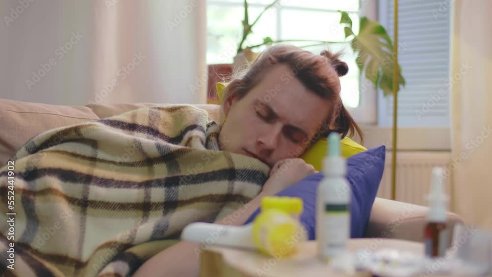 Sick young man coughing resting on couch at home. Realtime Sick young man coughing resting on couch at home. Realtime