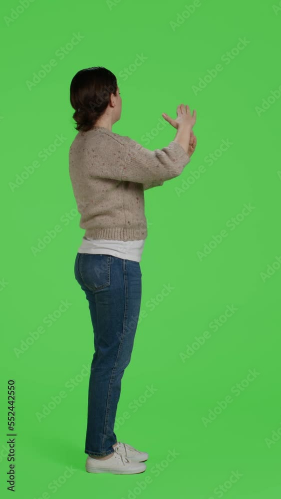 Vertical video: Profile of female model doing t shape break gesture on green screen backdrop, showing timeout or pause symbol with arms. Woman posing over full body greenscreen with refusal sign in Vertical video: Profile of female model doing t shape break gesture on green screen backdrop, showing timeout or pause symbol with arms. Woman posing over full body greenscreen with refusal sign in