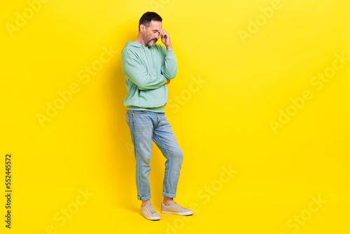 Full length photo of minded man hand touch head eyes closed lost money bankrupt stand empty space isolated on yellow color background