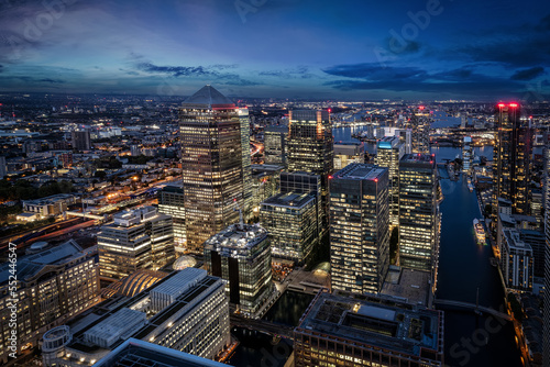 Elevated view of the illuminated office skyscrapers at Canary Wharf, London, during evening © moofushi