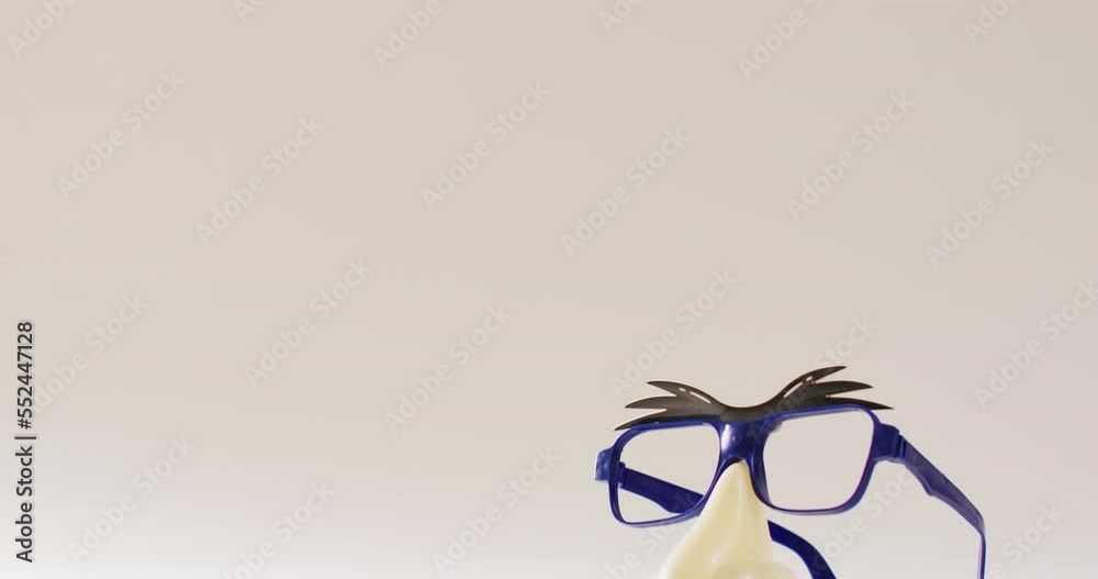 Video of attached plastic eyebrows, glasses, nose and moustache on white background with copy space Video of attached plastic eyebrows, glasses, nose and moustache on white background with copy space