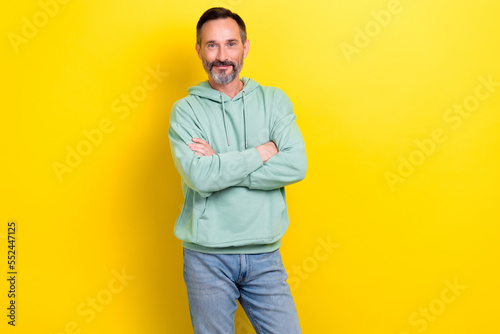 Photo of confident smiling good mood business man wear pastel green hoodie crossed hands look you new vacancy isolated on yellow color background