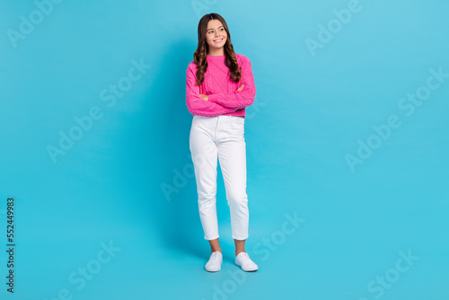 Full length photo of sweet adorable girl dressed knit pullover arms crossed looking empty space isolated blue color background