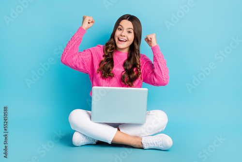 Full length photo of lucky sweet girl dressed knit pullover rising fists reading modern gadget isolated blue color background © deagreez