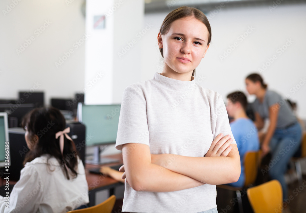 Portrait of smiling caucasian teen schoolgirl in the computer class of the school
