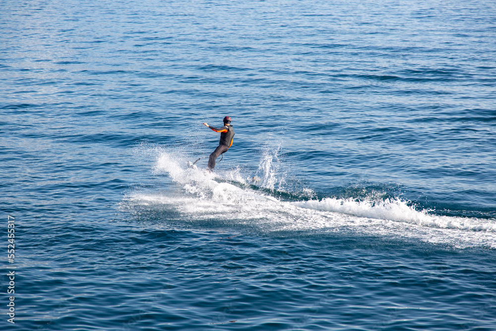 A man rides on an electric surfboard. Surf on an electric board A man rides on an electric surfboard. Surf on an electric board