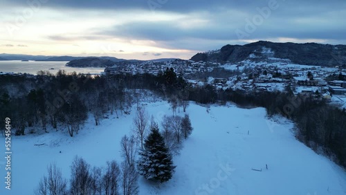 Flight toward the harbor of the coastal town of Osøyro, Bjørnafjorden, Norway during winter. Sunset.