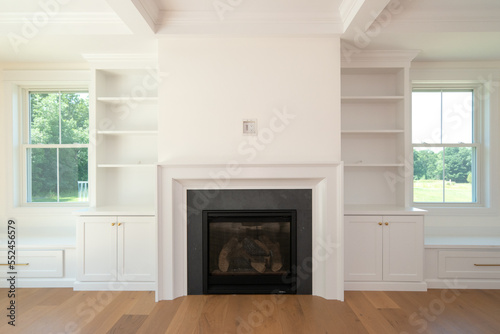 Photography Living room with built in bookcases and fireplace and seats under window close u