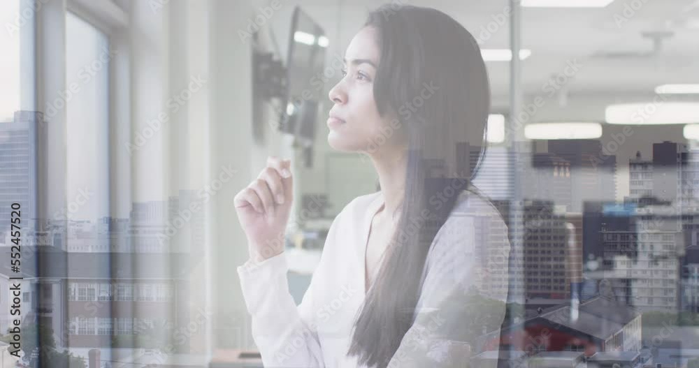 Animation of cityscape over biracial businesswoman in office Animation of cityscape over biracial businesswoman in office