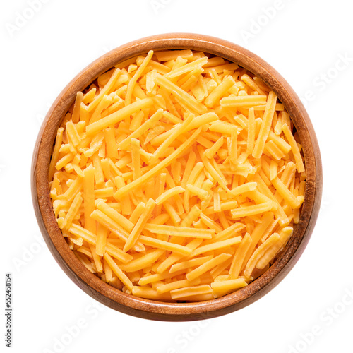Shredded cheddar cheese, in a wooden bowl. Grated natural cheese, piquant, colored orange with annatto, a natural food coloring. Rolled in starch to avoid sticking. Used for pizza and pasta dishes.