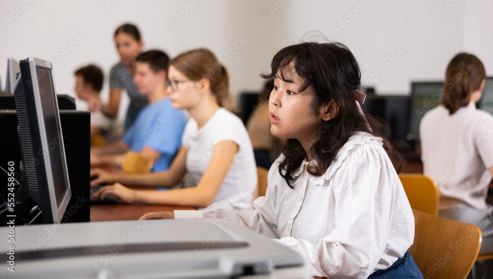 Fototapeta premium Asian girl using computer during computer sciene lesson in school.