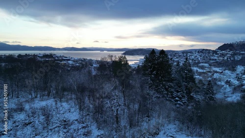 Flight toward the harbor of the coastal town of Osøyro, Bjørnafjorden, Norway during winter. Sunset.