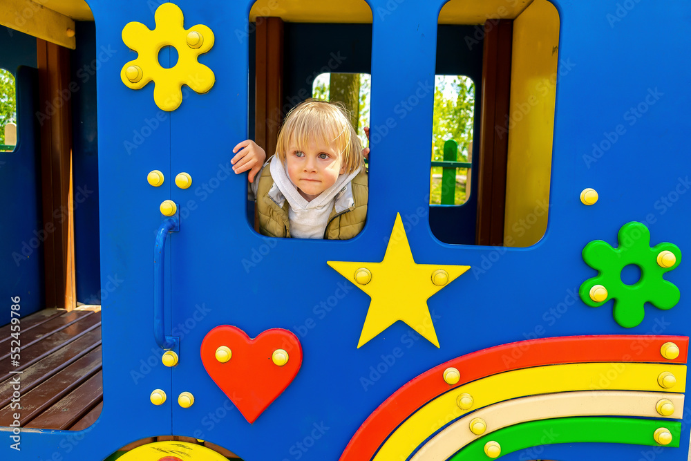 Cute little kid child boy in toy car,bus, train in playground.Children