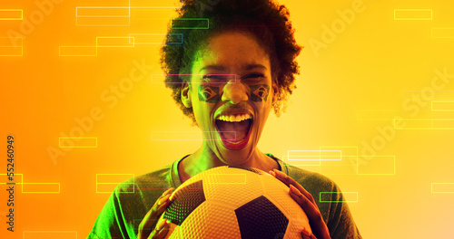 Biracial female soccer player with brazilian flag's face paint screaming over illuminated rectangles