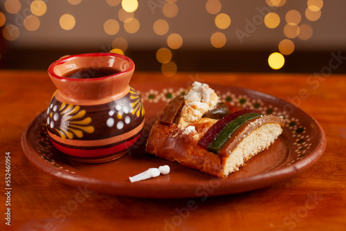 Slice of traditional rosca de reyes on a plate and coffee photo