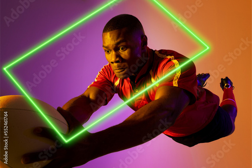 Rectangle neon over african american young rugby player jumping against colored background