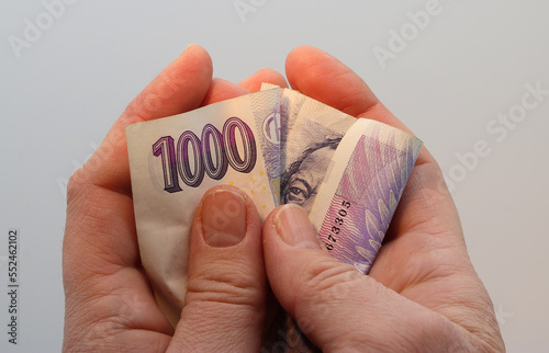 фотографія A woman´s hands are clutching a thousand Czech crown banknote