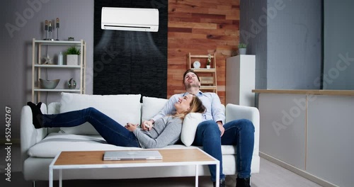 Happy Family Couple Using Air Conditioner photo