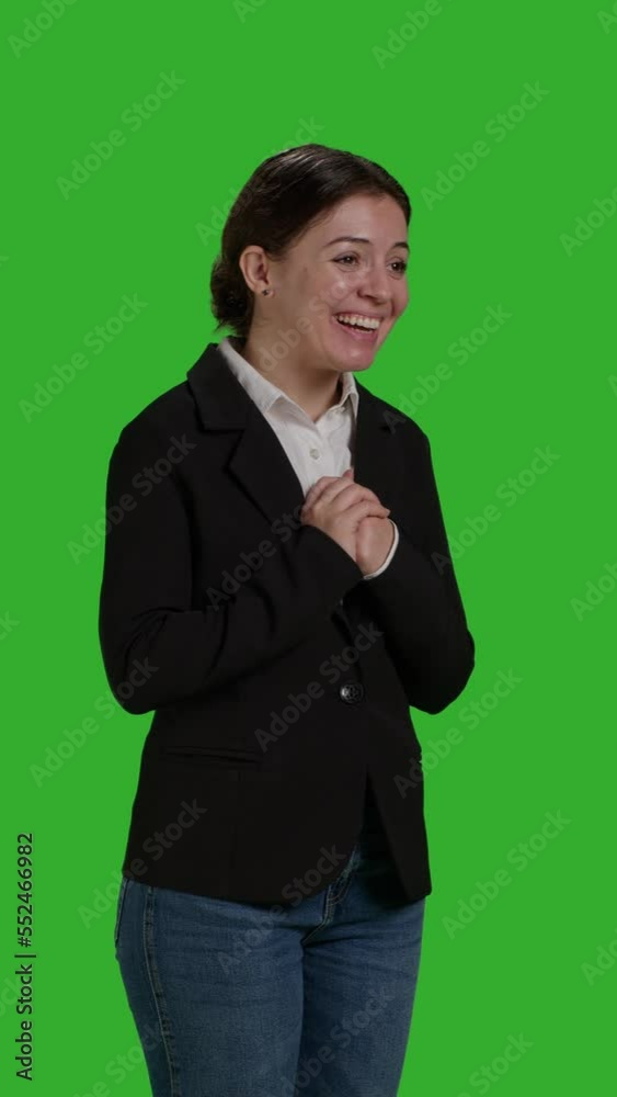 Vertical video: Side view close up of smiling businesswoman waving hello or goodbye in studio, doing greeting gesture over greenscreen backdrop. Cheerful manager saying hi, wearing suit on full body Vertical video: Side view close up of smiling businesswoman waving hello or goodbye in studio, doing greeting gesture over greenscreen backdrop. Cheerful manager saying hi, wearing suit on full body