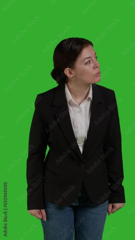 Vertical video: Front view close up of focused businesswoman standing over greenscreen backdrop, acting optimistic and confident in studio. Corporate worker wearing office suit on camera, stylish Vertical video: Front view close up of focused businesswoman standing over greenscreen backdrop, acting optimistic and confident in studio. Corporate worker wearing office suit on camera, stylish
