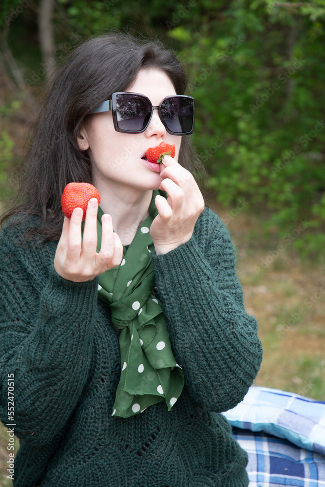 Εκτύπωση καμβά young beautiful brunette woman eat strawberry dessert at picnic on the bench