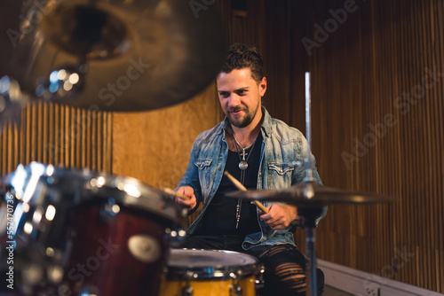 Young man musician playing drums in a studio. High quality photo © PoppyPix
