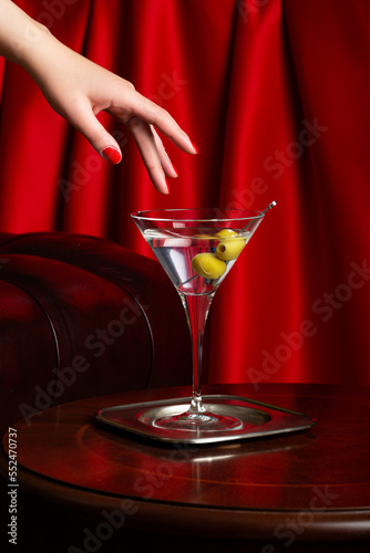 Martini glass in female hand in luxury interior