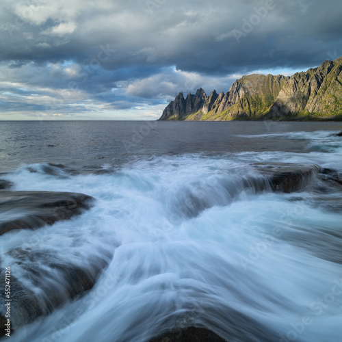 Waves flow over rocky shoreline at Tungeneset viewpoint, Senja, Norway