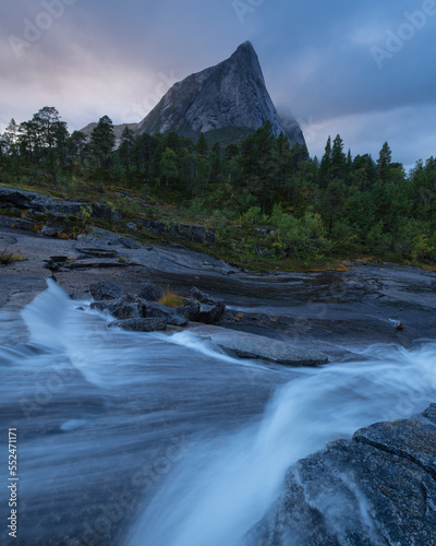 Stortinden mountain peak rises over flowing stream, Nordland, Norway