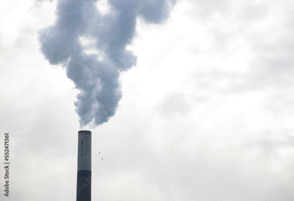 Industrial chimney, thermal power plant, pollution in the air, steam cooling tower in Graz, Styria region, Austria.