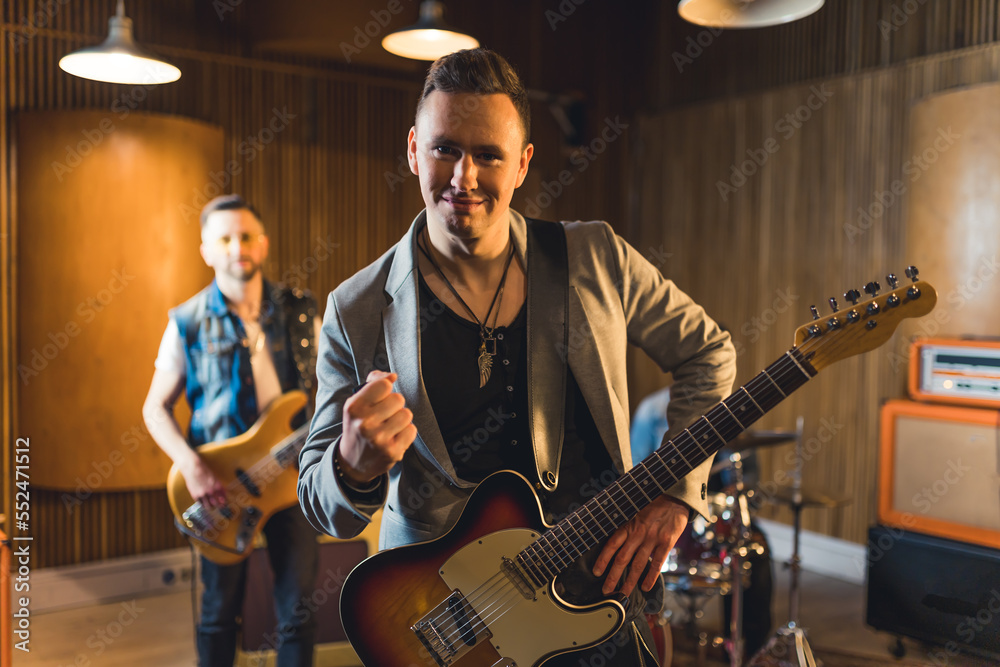 Fototapeta premium Man poses with an electric guitar during a music band performance . High quality photo