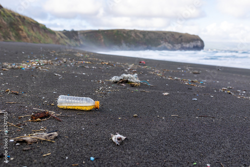 Billede på lærred Trash in the sand, plastic waste by the ocean, sad and unsustainable