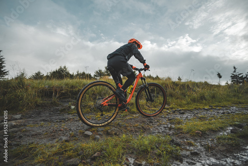Ciclista en bicicleta de monta  a en camino de tierra entre el bosque