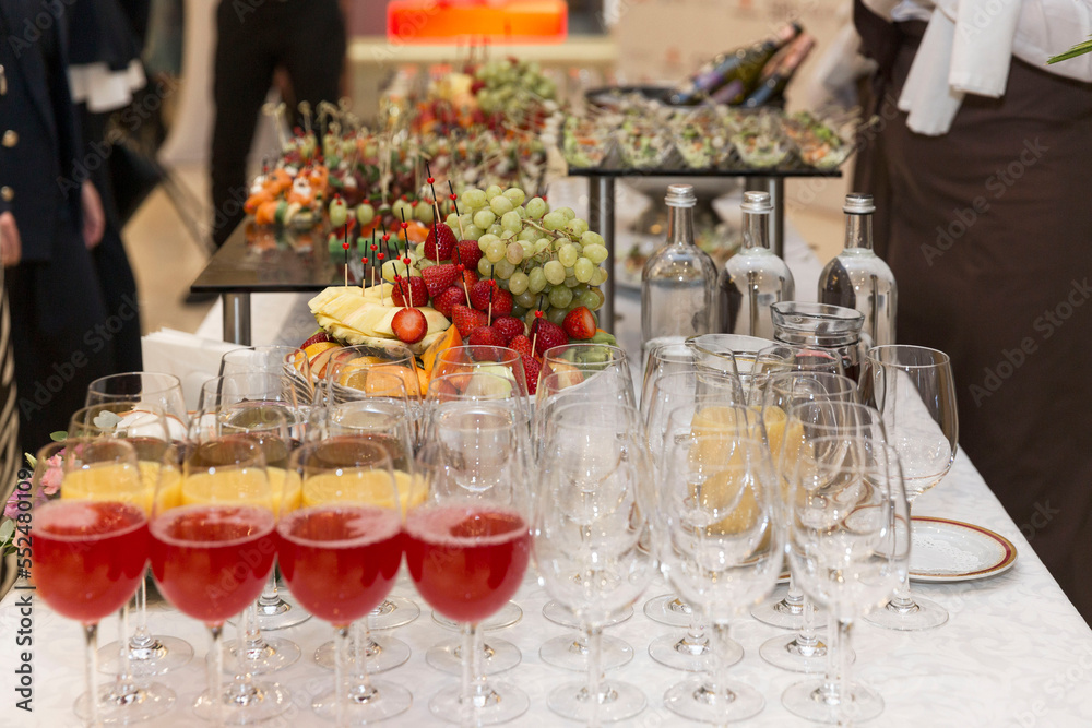 Drinks and snacks on the festive buffet table. Appetizing canapes, fruits and alcohol. Catering for events.