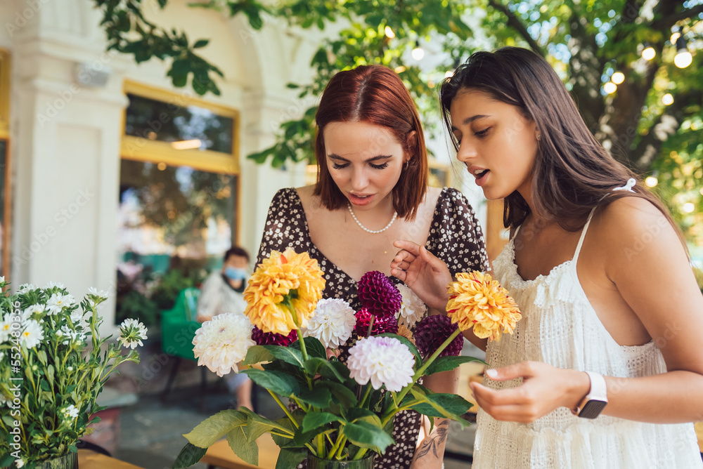 Two young women make up a beautiful festive bouquet.