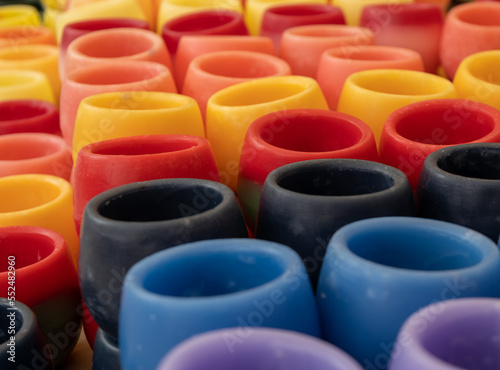 Wax containers of various colors on a table.