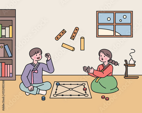 Korean traditional game. Two friends are playing Yut in their room. photo