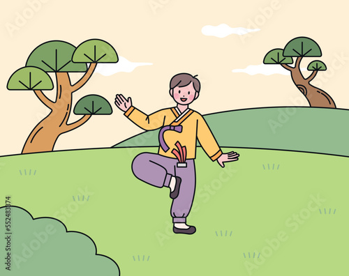 A boy wearing hanbok and playing Jegichagi, a traditional Korean game.