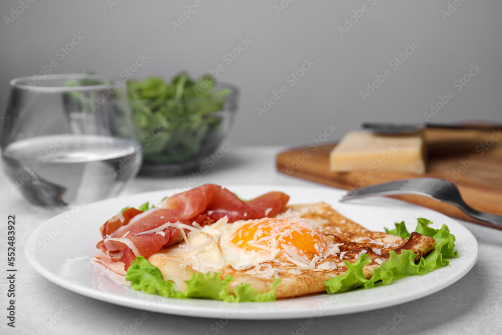 Delicious crepe with egg served on light gray table. Breton galette Delicious crepe with egg served on light gray table. Breton galette