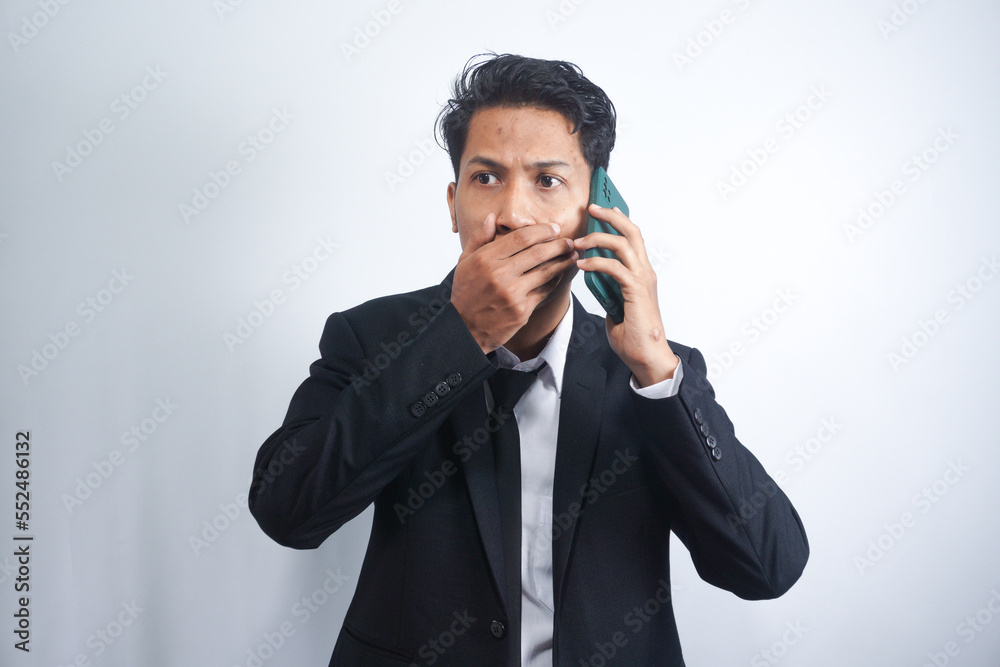 Young Asian Man is confused and shocked when calling in the phone. Indonesian man wearing a black shirt. Young Asian Man is confused and shocked when calling in the phone. Indonesian man wearing a black shirt.