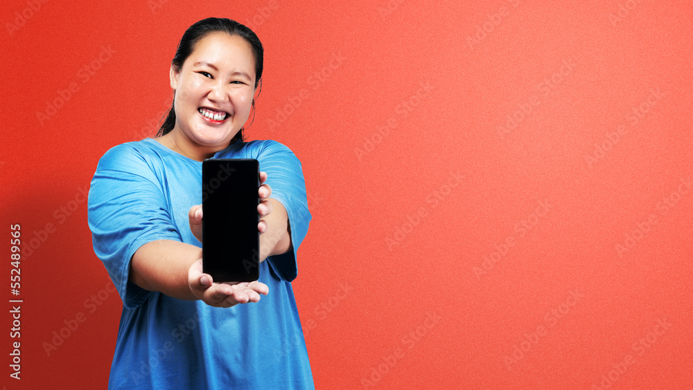 Asian fat overweight woman holding a mobile phone and showing an empty screen Asian fat overweight woman holding a mobile phone and showing an empty screen