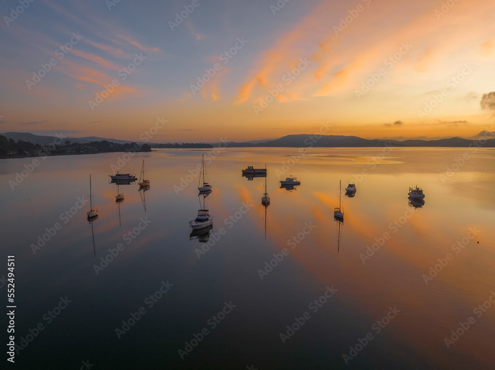Sunrise over the water with fog, boats, clouds and reflections