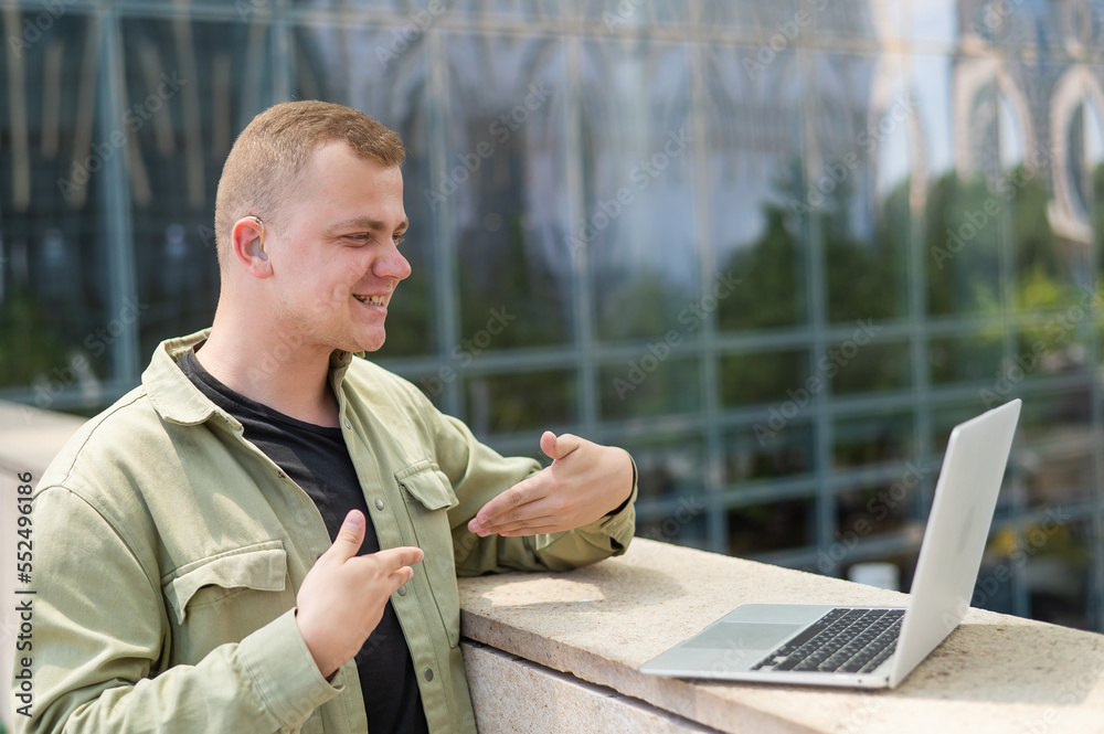 Caucasian man communicates in sign language via video link on laptop. Caucasian man communicates in sign language via video link on laptop.