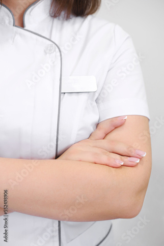 Crossed arms of a medical worker in a white coat. Close-up